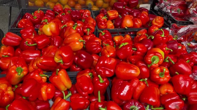 Vegetable section counter in supermarket full of fresh red bell peppers rich in vitamin c bright colors healthy nutrition natural food abundance and freshness concept