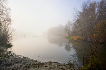 Foggy dawn in autumn by the river.