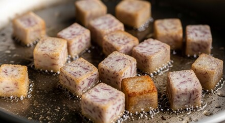 Golden Fried Cubes of Exotic Taro Root Cooking in a Pan with Boiling Oil