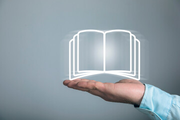 A businessman touches a book icon on the screen