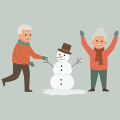  A happy elderly man and woman built a snowman.