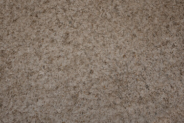 Rough concrete wall creating a textured background, showing a weathered surface with natural stone elements, suitable for architectural and construction concepts