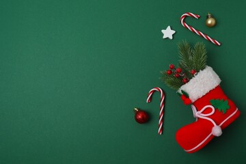 Christmas Santa's boot with gifts and decoration on colorful green background. Minimal Christmas...
