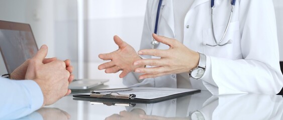 Doctor discussing medical information with patient during consultation, providing expert healthcare...