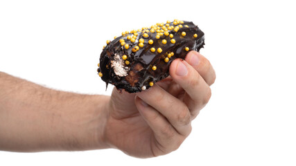 Delicious chocolate dessert with colorful sprinkles held in hand against a white background