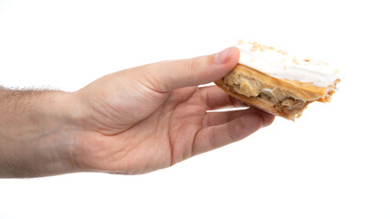 Delicious dessert being held in hand, showcasing layers of cream and peanut butter