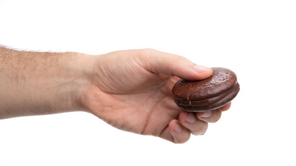 Hand holding a brown circular wooden item, showcasing craftsmanship and detail in design by artisan makers