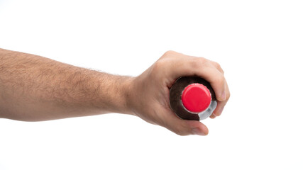 Hand gripping a beverage bottle with a bright red cap in a neutral setting during the day
