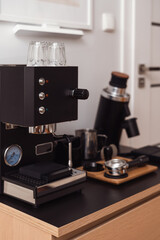 Modern black coffee machine making fresh espresso in stylish home kitchen