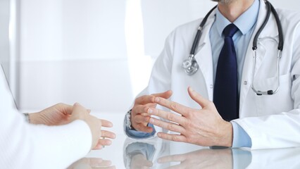 Fototapeta premium Doctor consulting patient about healthcare, discussing diagnosis, offering medical advice in clinic. Medicine, healthcare and science concept