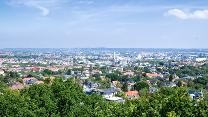 View from the Fichteturm overlooking Dresden, showing the cityscape surrounded by greenery and distant horizon.