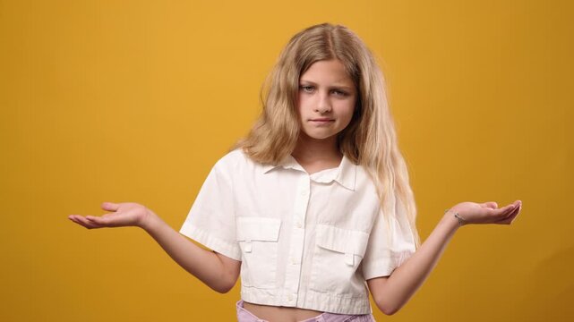Confused clueless young girl shrugging her shoulders