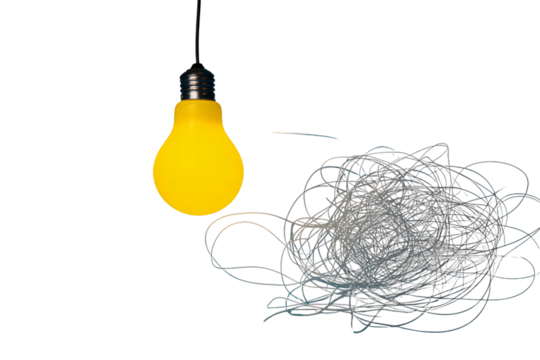Bright yellow lightbulb illuminates tangled mess of string against dark backdrop