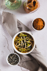 Asian broccoli noodle miso soup in a bowl on the table top and vertical view