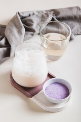 Cloudy pink matcha with taro vegetable in a glass on the table vertical view