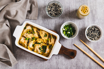 One-Pan Baked Dumplings with Herbs and Sauce in a Pan on the Table top view