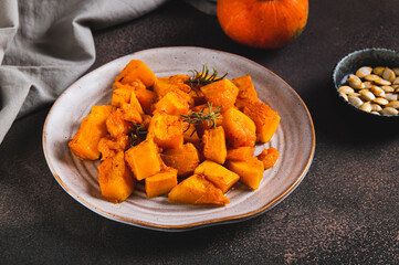 Roasted pumpkin with rosemary on a plate on the table