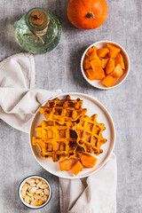 Homemade autumn pumpkin waffles on a plate on the table top and vertical view