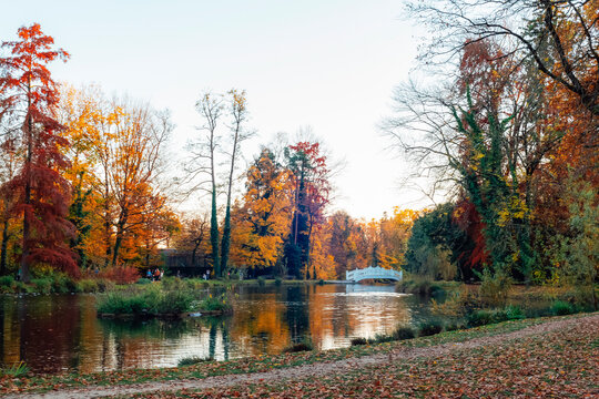 Autumn park with colorful trees and small white bridge over calm lake. Park Maksimir, Zagreb, Croatia