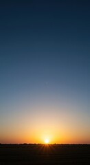 Fototapeta premium The sun slowly breaks the horizon, casting soft, cool light over the landscape, signaling the final moments of a long, dark period ,sunrise ,natural ,beginning