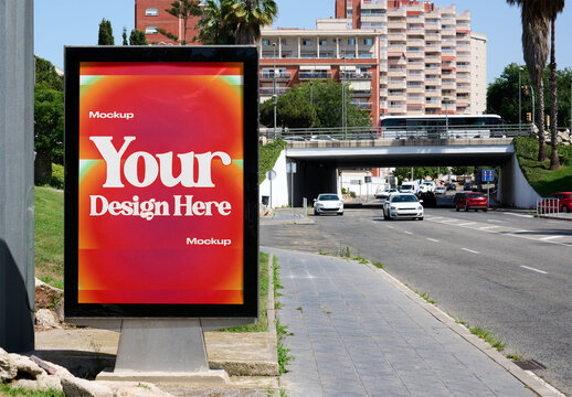 A blank advertising display stands along a busy road with cars passing by.