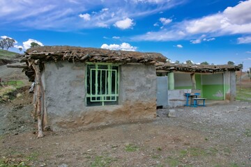 Traditional rural life in a Kurdish village, featuring a weathered stone and wood shelter and a dirt path