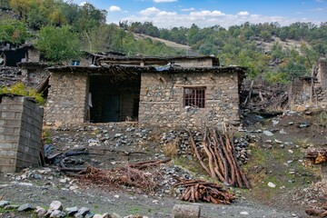 Traditional rural life in a Kurdish village, featuring a weathered stone and wood shelter and a dirt path