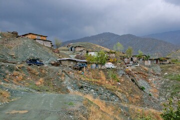 Traditional rural life in a Kurdish village, featuring a weathered stone and wood shelter and a dirt path
