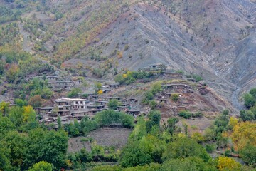 Traditional rural life in a Kurdish village, featuring a weathered stone and wood shelter and a dirt path