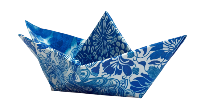 PNG of A beautifully crafted origami boat in intricate blue and white floral patterns, showcasing elegance and creativity.