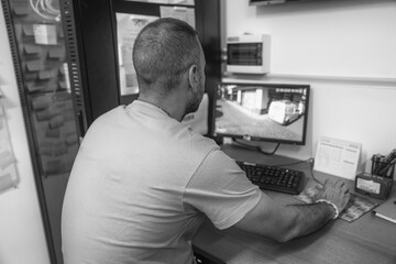 IT professional checking live video feeds from CCTV cameras on desktop setup