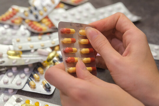 Hands pushing pill from blister pack close up medicine concept