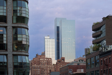 Fototapeta premium Low-angle view of modern skyscrapers in Manhattan, New York City. This dramatic perspective emphasizes the towering height and sleek design of the city's contemporary architecture. 