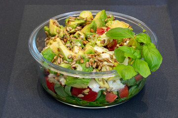 Avocado salad and tomatoes with rocket and sunflower seeds