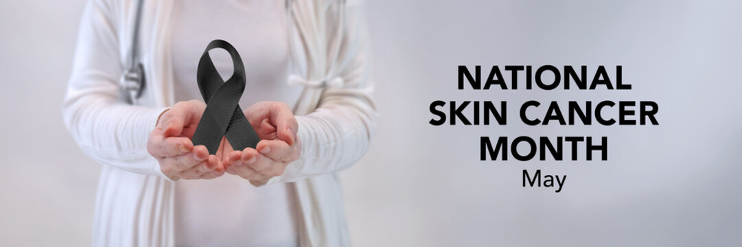 Doctors Hands Presenting Black Awareness Ribbon - Skin Cancer Awareness Concept