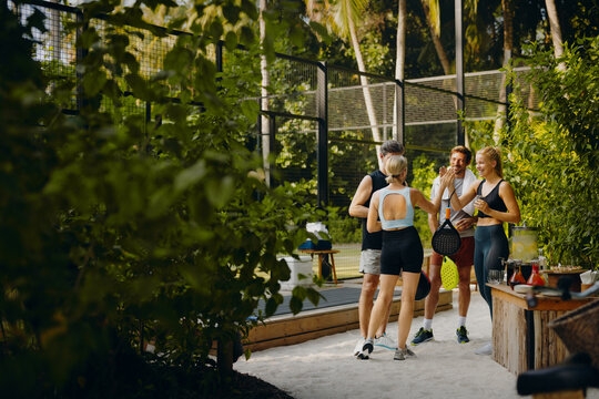 Family standing outside a padel court at a luxury resort - Powered by Adobe