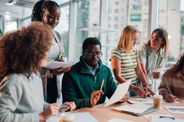 Diverse startup team collaborating on creative projects in modern office
