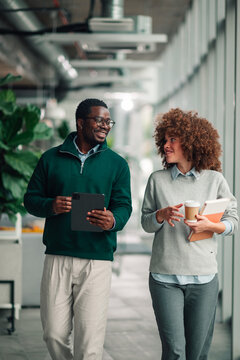 Diverse coworkers walking office communicating discussing business
