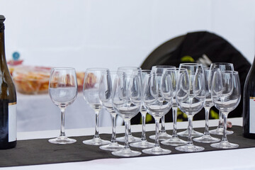 Elegant arrangement of wine glasses on a black tablecloth, with a bottle of sparkling wine nearby, creating a sophisticated atmosphere for a celebration or gathering with friends and family