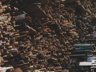 Stacked firewood filling the frame, multiple layers of cut logs creating a rich pattern of textures and tones, warm matte finish enhancing the natural character of the wood, authentic rustic