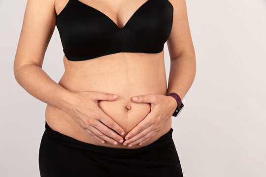 Mujer embarazada con lencer&iacute;a negra.