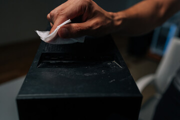 Close-up of technician hand cleaning dust and grime from computer case with tissue, ensuring optimal performance and hygiene. Concept of importance of regular cleaning for optimal performance.