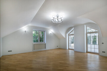 A spacious, empty room with parquet floors and natural light in a modern residential building.