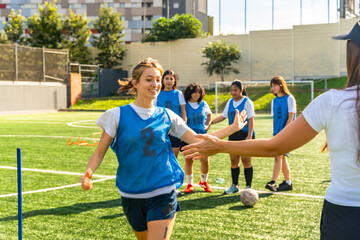 Obraz premium Young female soccer player high fiving coach after training