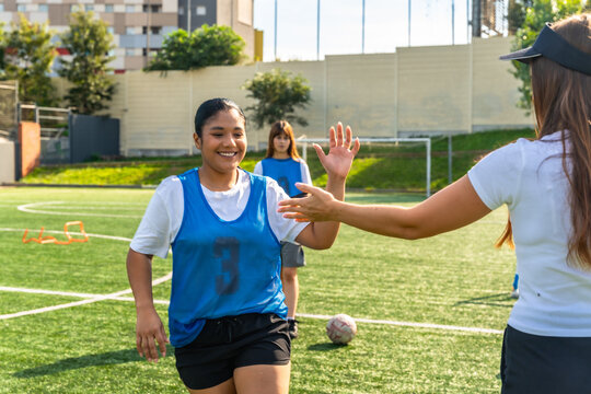 Female soccer player high fiving coach during training