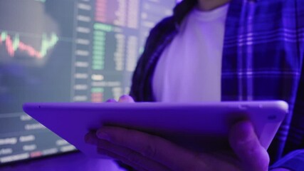 Stock market broker holding digital tablet while analyzing graphs. Slow motion - Powered by Adobe