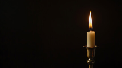 Single candle flame illuminates the darkness, casting a warm glow against the black background. Symbolizing hope and remembrance, it offers a tranquil ambiance. Wax softly melting.