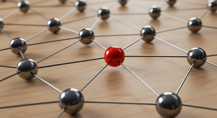 Dynamic network of interconnected spheres with a single striking red node representing innovation and connection on a warm wooden surface.