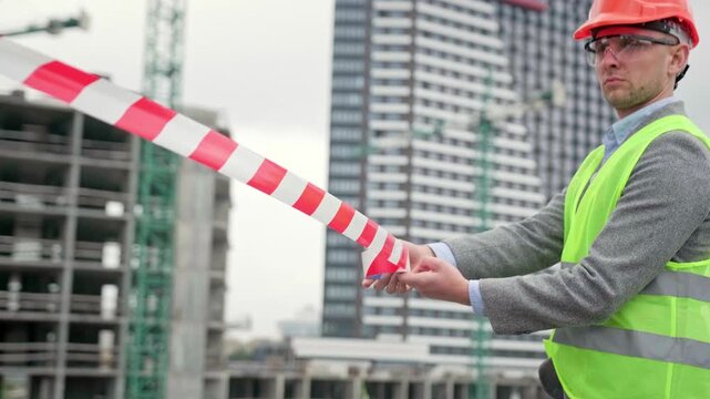 Serious construction superintendent cordoning off building site