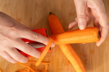 Fresh Carrot Peeling with Knife Close Up, Raw Carrot Slices, Orange Root Vegetable
